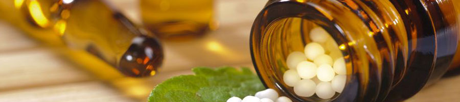 Apothekerflaschen mit Globuli und einem Pfefferminzblatt